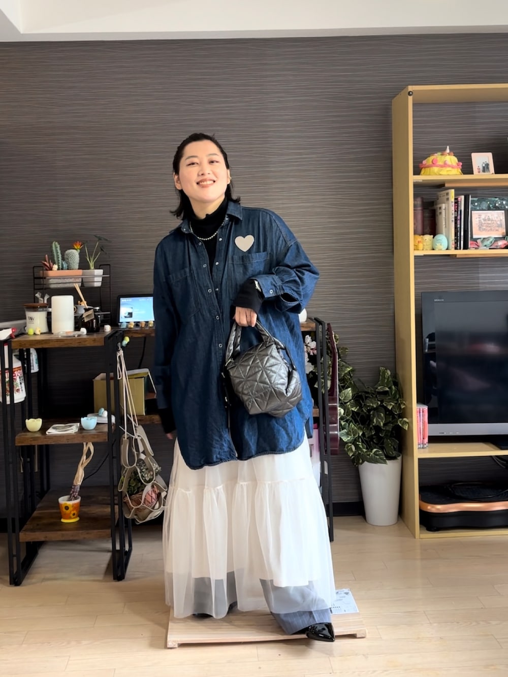 ブラック系のハンドバッグ、ブルー系のシャツ/ブラウス、ブラック系のTシャツ/カットソーを着用したレディースの春コーディネートの3枚目の写真