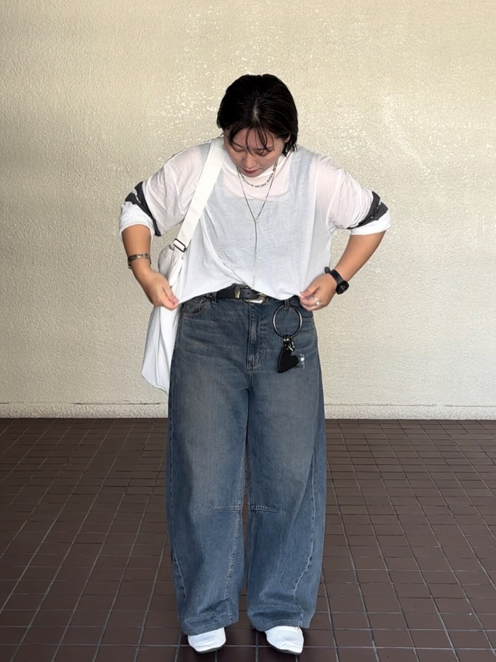 ブルー系のデニムパンツ、ホワイト系のTシャツ/カットソーを着用したレディースの秋コーディネートの2枚目の写真