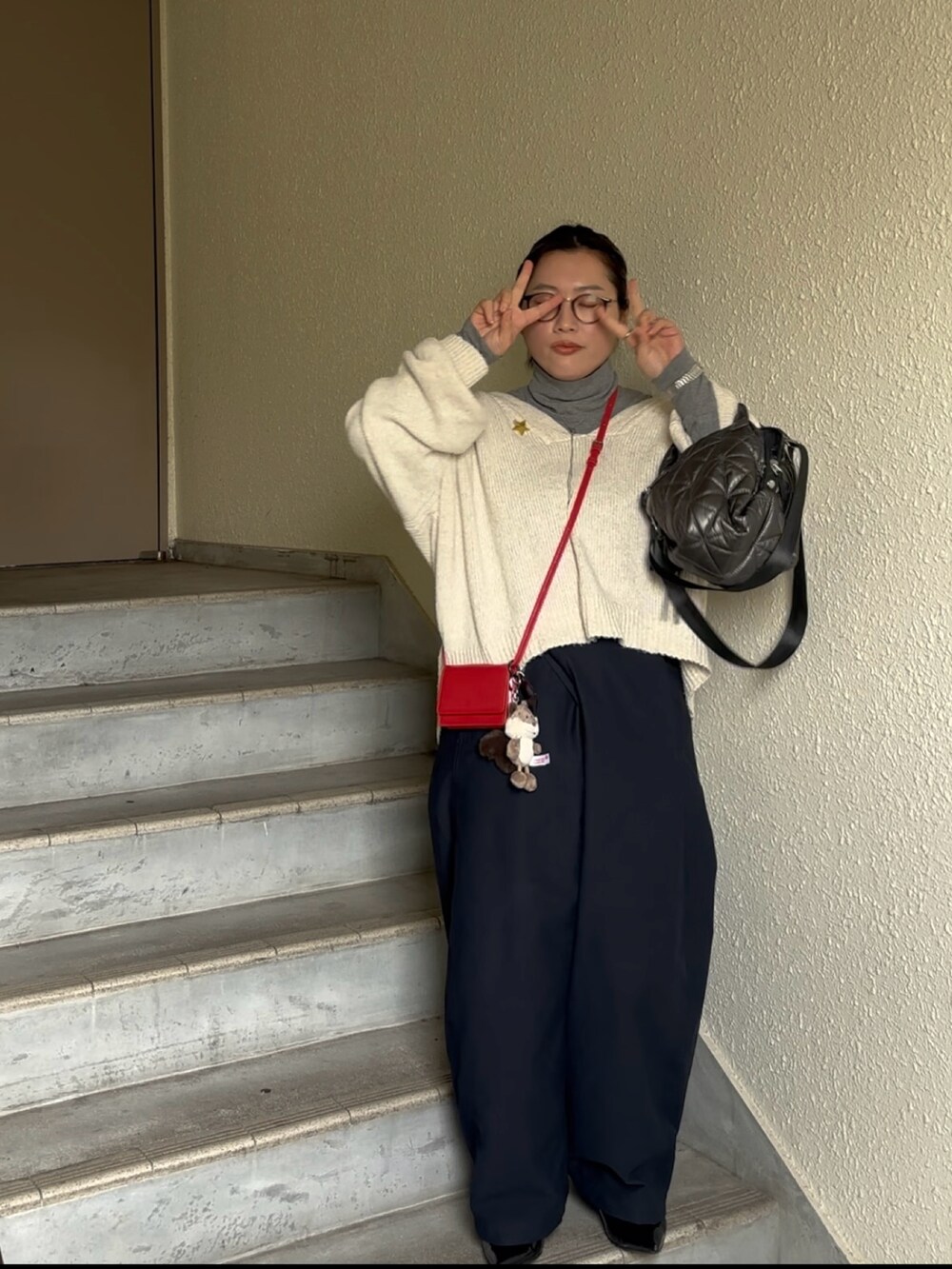 ホワイト系のニット/セーター、グレー系のTシャツ/カットソー、ブルー系のチノパンツを着用したレディースの春コーディネートの2枚目の写真