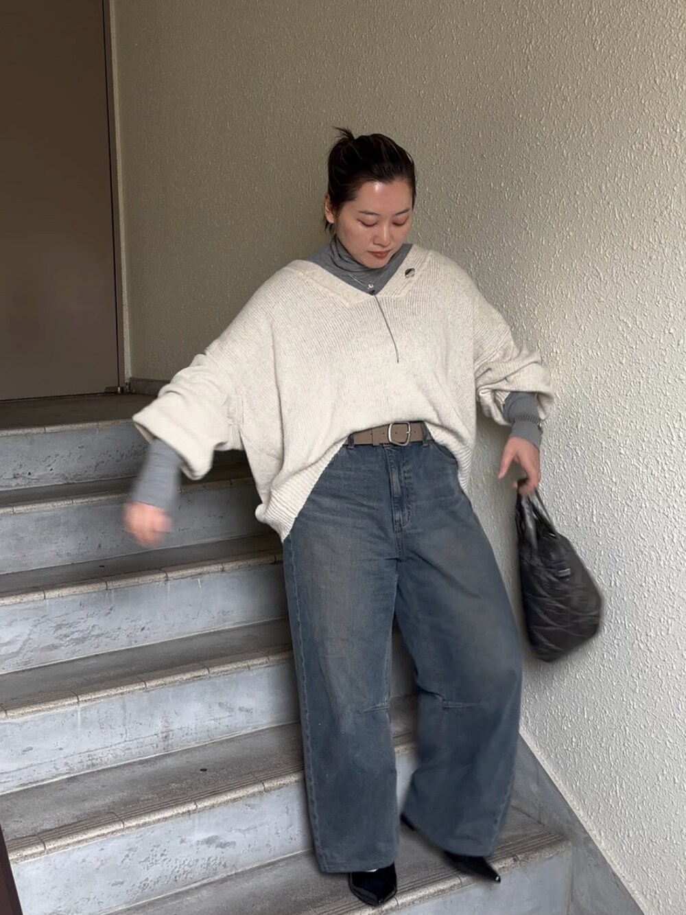 ホワイト系のニット/セーター、ブルー系のデニムパンツ、ブラック系のパンプスを着用したレディースの春コーディネートの2枚目の写真