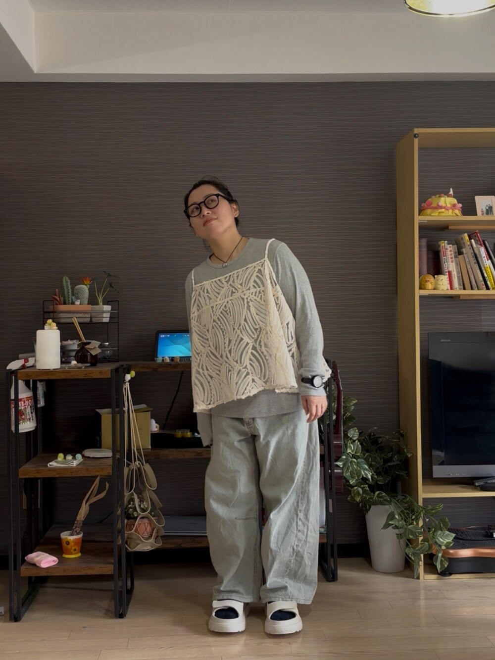 ブルー系のデニムパンツ、ホワイト系のサンダル、ベージュ系のキャミソールを着用したレディースの夏コーディネートの2枚目の写真