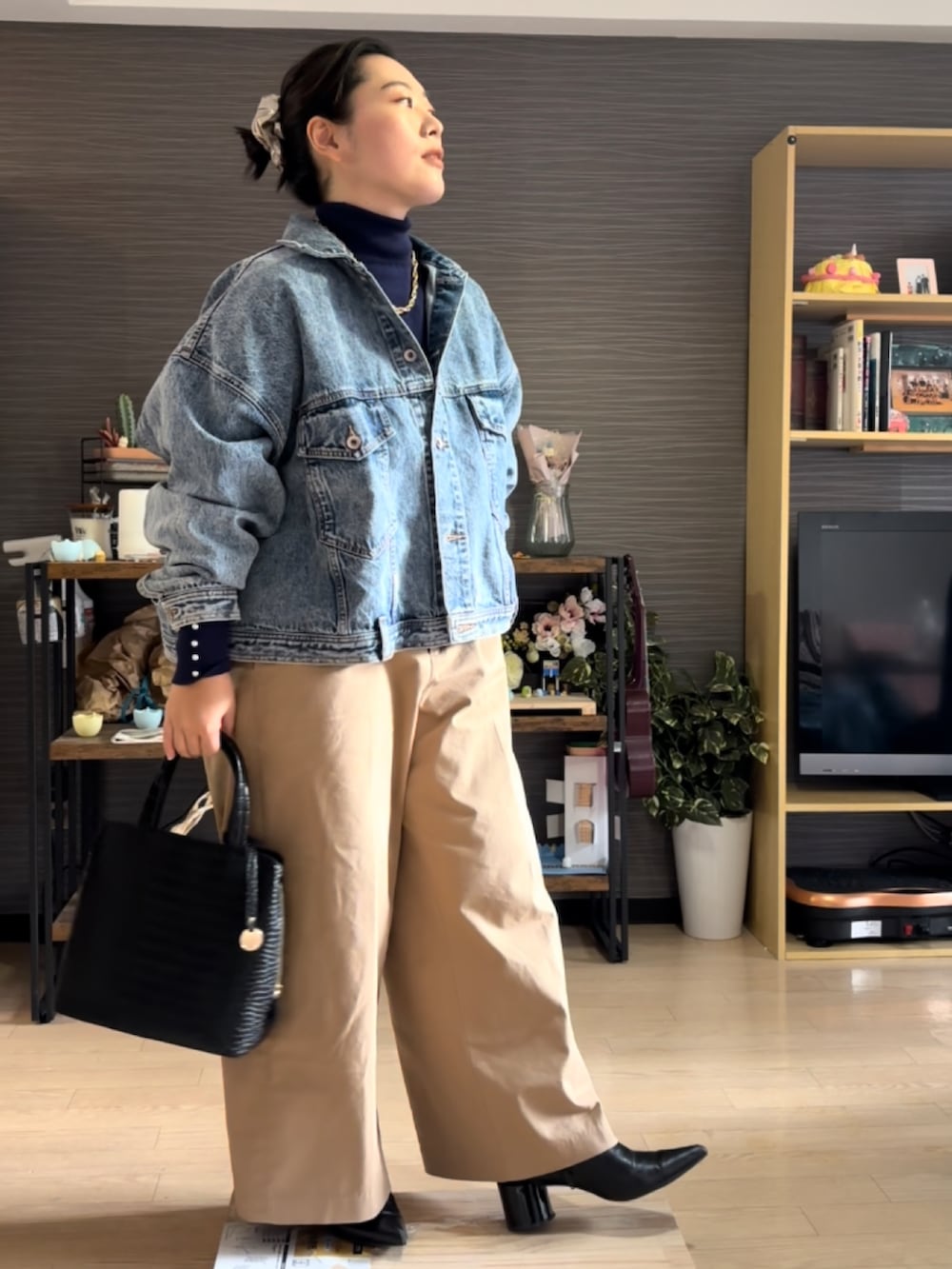 ベージュ系のチノパンツ、ブラック系のブーツ、ブルー系のデニムジャケットを着用したレディースの冬コーディネートの2枚目の写真