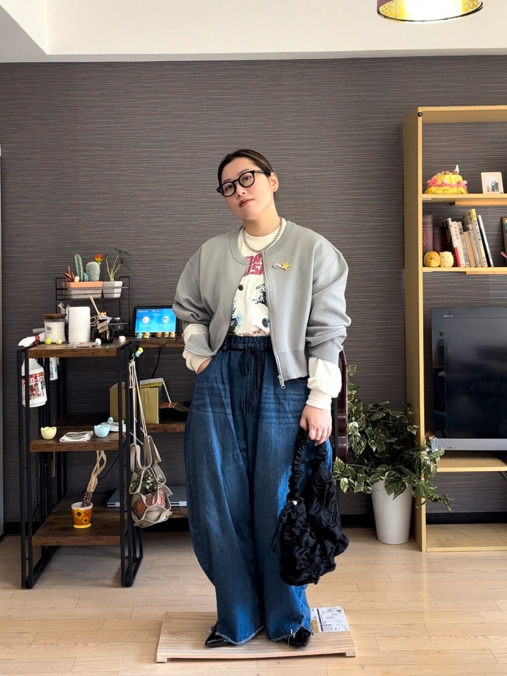 グレー系のカーディガン/ボレロ、ホワイト系のTシャツ/カットソー、ブルー系のデニムパンツを着用したレディースの春コーディネートの2枚目の写真