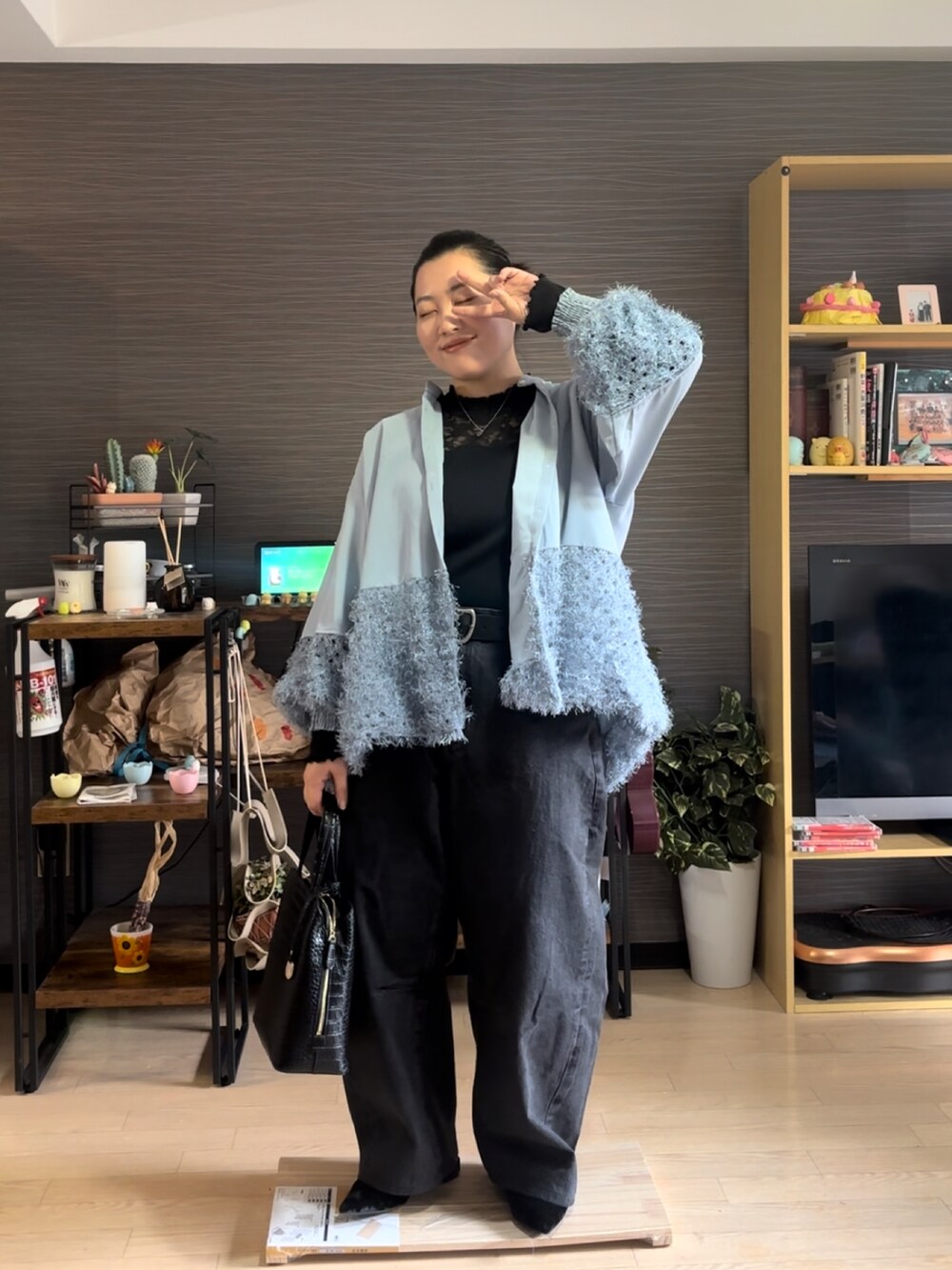 ブルー系のシャツ/ブラウス、ブラック系のデニムパンツ、ブラック系のバッグを着用したレディースの冬コーディネートの3枚目の写真