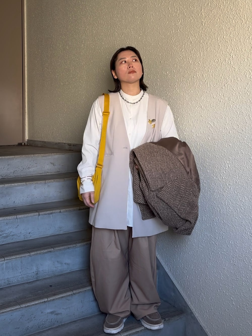 ベージュ系のパンツ、ベージュ系のブーツ、ベージュ系のスーツベストを着用したレディースの春コーディネートの2枚目の写真