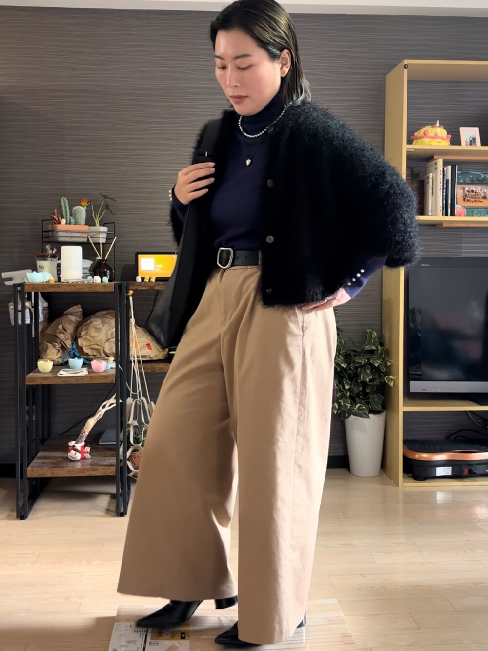 ベージュ系のチノパンツ、ブラック系のブーツ、ブラック系のバッグを着用したレディースの冬コーディネートの2枚目の写真