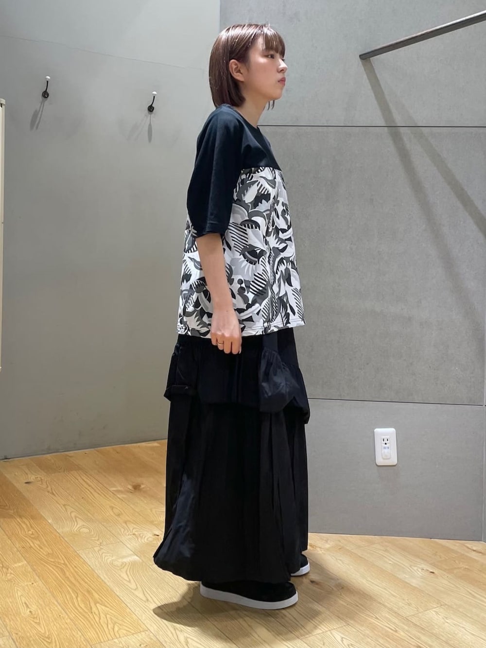 ブラック系のTシャツ/カットソー、ブラック系のスカート、ブラック系のその他シューズを着用したレディースの春コーディネートの4枚目の写真