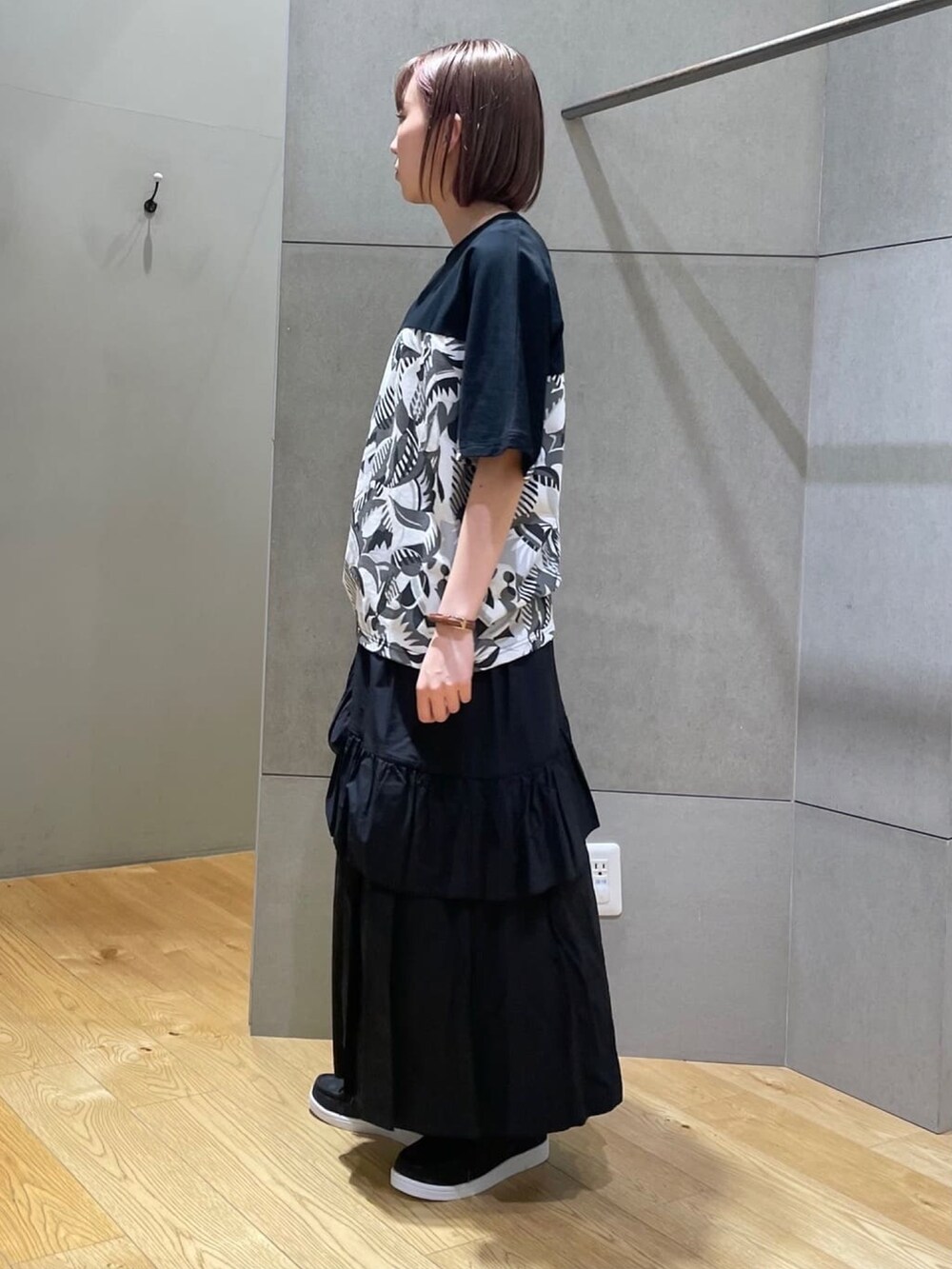 ブラック系のTシャツ/カットソー、ブラック系のスカート、ブラック系のその他シューズを着用したレディースの春コーディネートの2枚目の写真