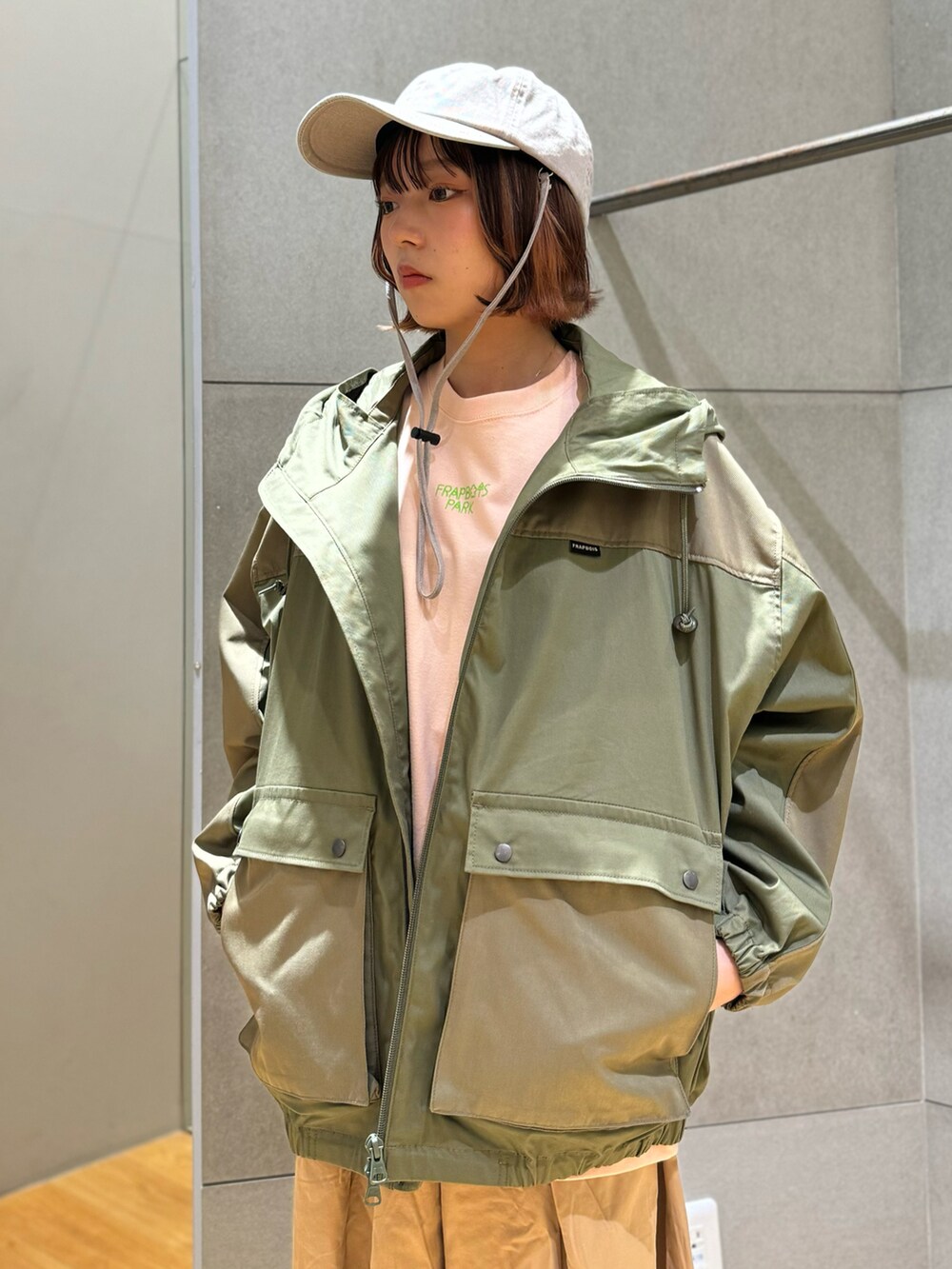 グリーン系のマウンテンパーカー、ピンク系のTシャツ/カットソー、ベージュ系のその他パンツを着用したレディースの春コーディネートの5枚目の写真