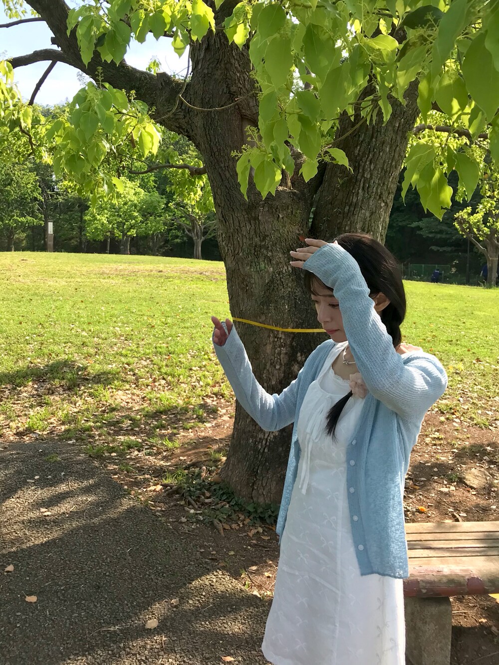 ブルー系のカーディガン/ボレロ、ブルー系のデニムパンツ、ホワイト系のタンクトップを着用したレディースの夏コーディネートの4枚目の写真