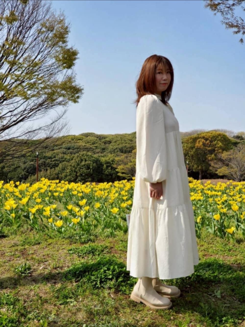 ホワイト系のワンピース、ホワイト系のブーツを着用したレディースの春コーディネートの2枚目の写真