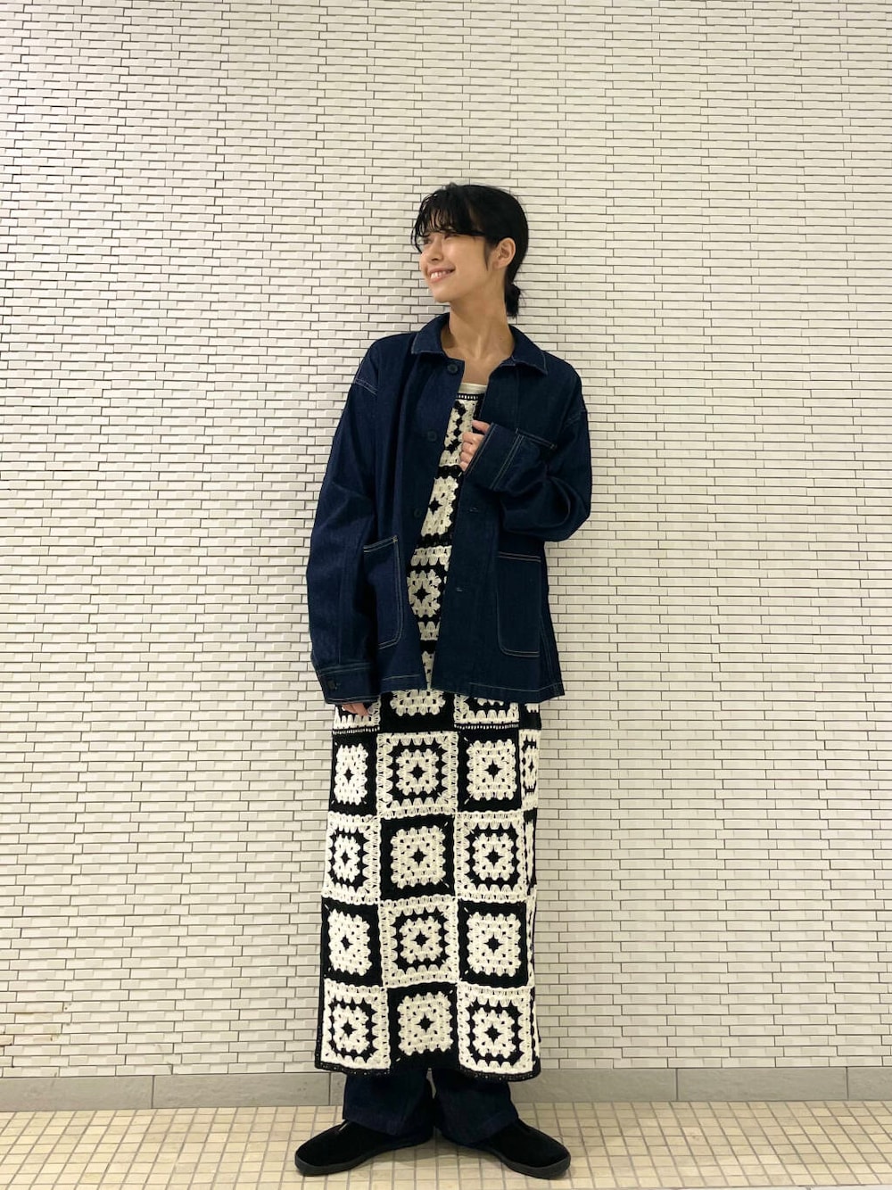 ブラック系のその他シューズ、ブルー系のデニムパンツ、ホワイト系のワンピースを着用したレディースの秋コーディネートの2枚目の写真