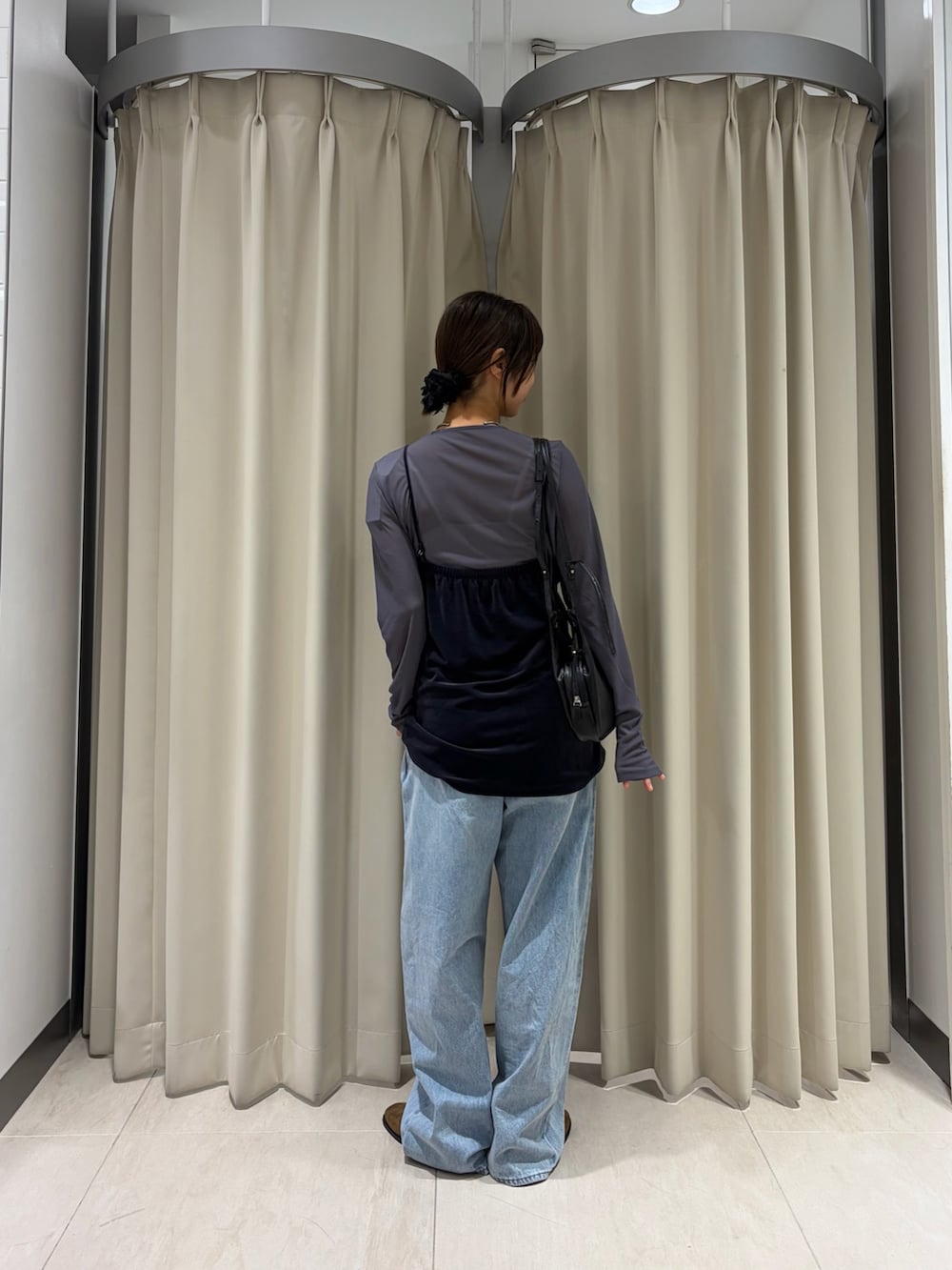 グレー系のTシャツ/カットソー、ブルー系のデニムパンツ、ブラウン系のその他シューズを着用したレディースの秋コーディネートの3枚目の写真