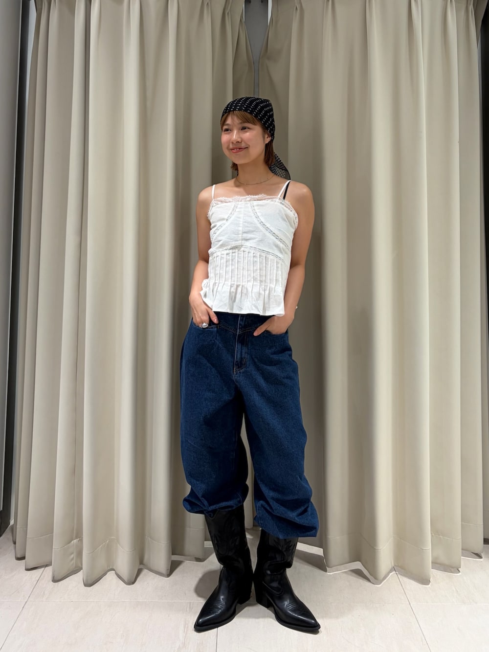 ブルー系のデニムパンツ、ホワイト系のキャミソールを着用したレディースの夏コーディネートの3枚目の写真