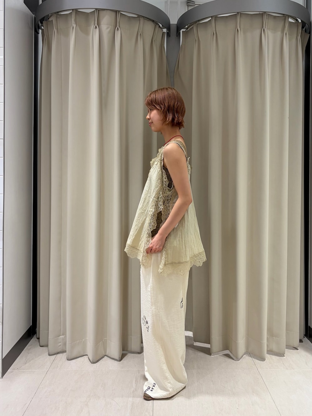 ベージュ系のキャミソール、ホワイト系のその他パンツ、イエロー系のショルダーバッグを着用したレディースの春コーディネートの3枚目の写真