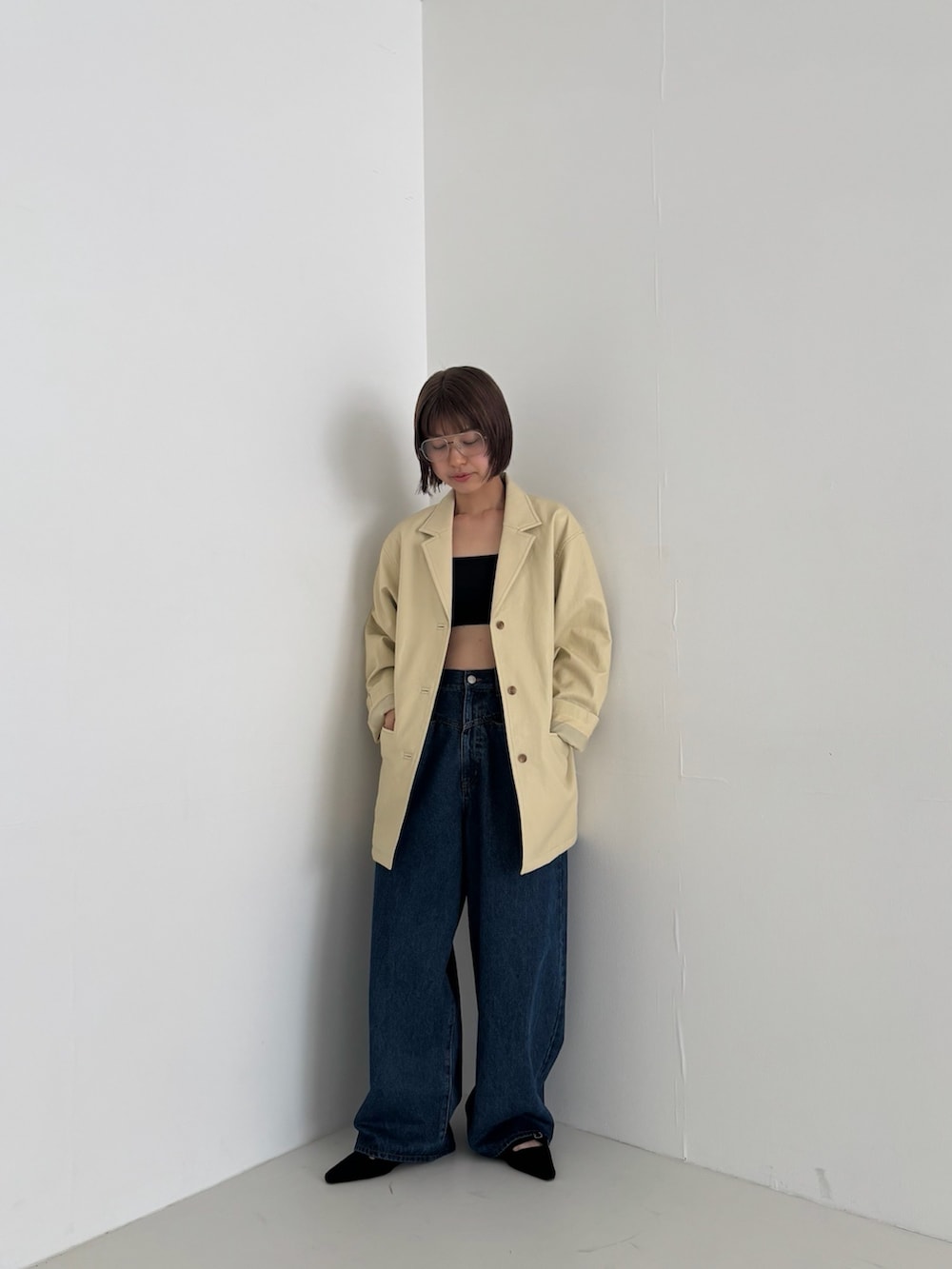 イエロー系のその他アウター、ブルー系のデニムパンツ、ブラック系のサンダルを着用したレディースの秋コーディネートの2枚目の写真