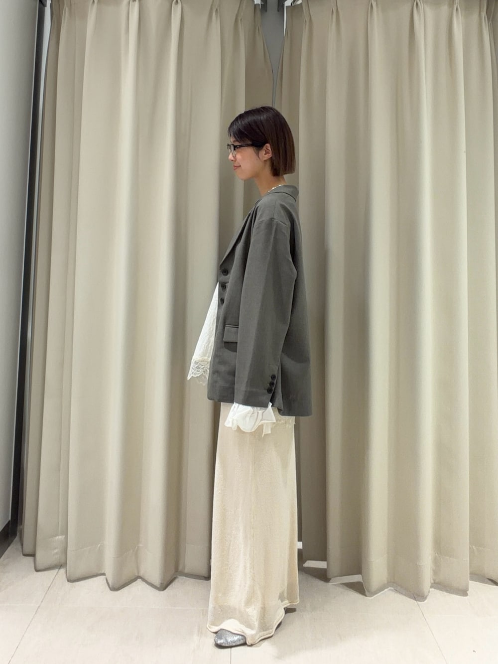 グレー系のその他アウター、ホワイト系のスカート、ホワイト系のシャツ/ブラウスを着用したレディースの春コーディネートの3枚目の写真