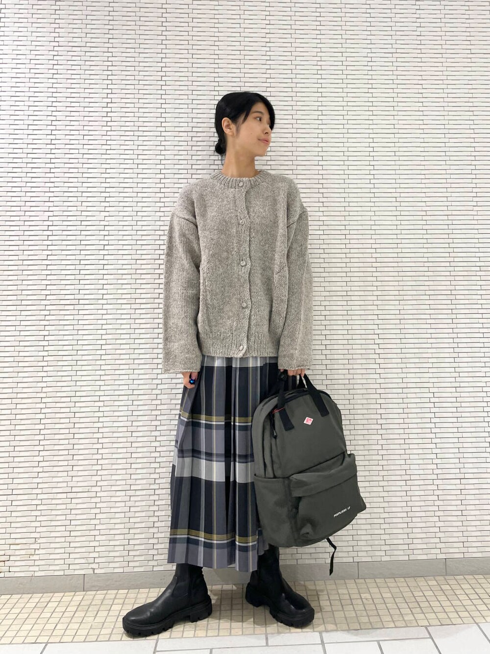 グレー系のニット/セーター、ブラック系のブーツ、ブラック系のスカートを着用したレディースの秋コーディネートの4枚目の写真