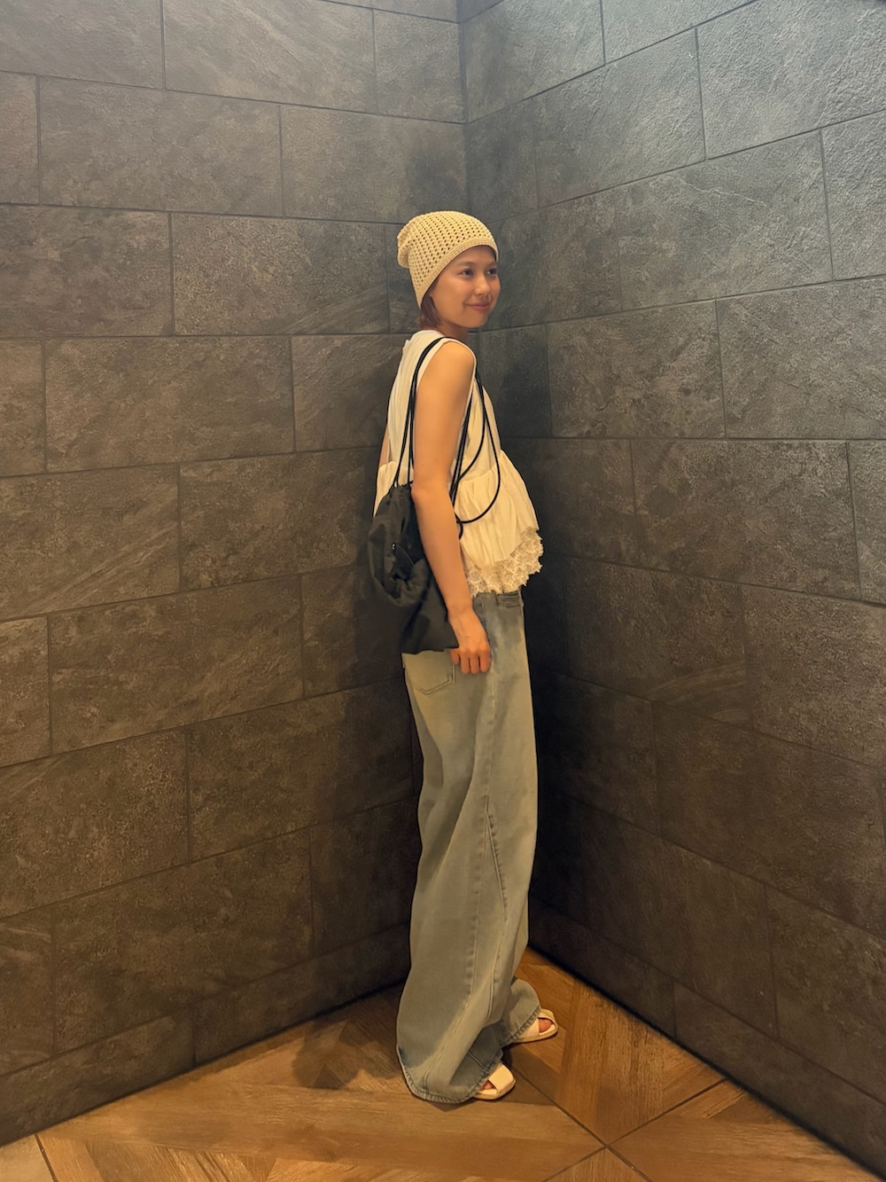 ブルー系のデニムパンツ、ホワイト系のその他トップス、ホワイト系のタンクトップを着用したレディースの夏コーディネートの2枚目の写真