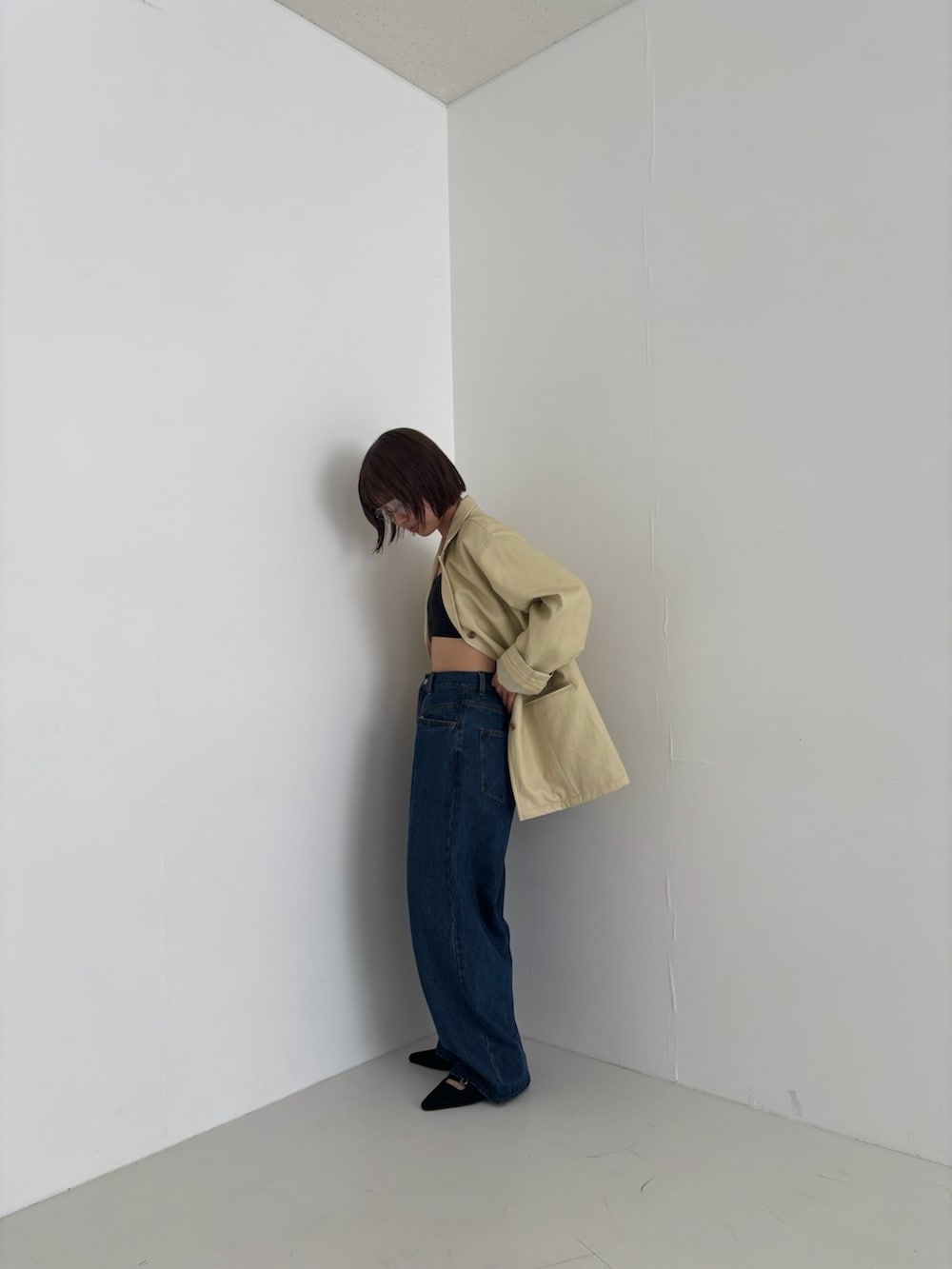 イエロー系のその他アウター、ブルー系のデニムパンツ、ブラック系のサンダルを着用したレディースの秋コーディネートの3枚目の写真