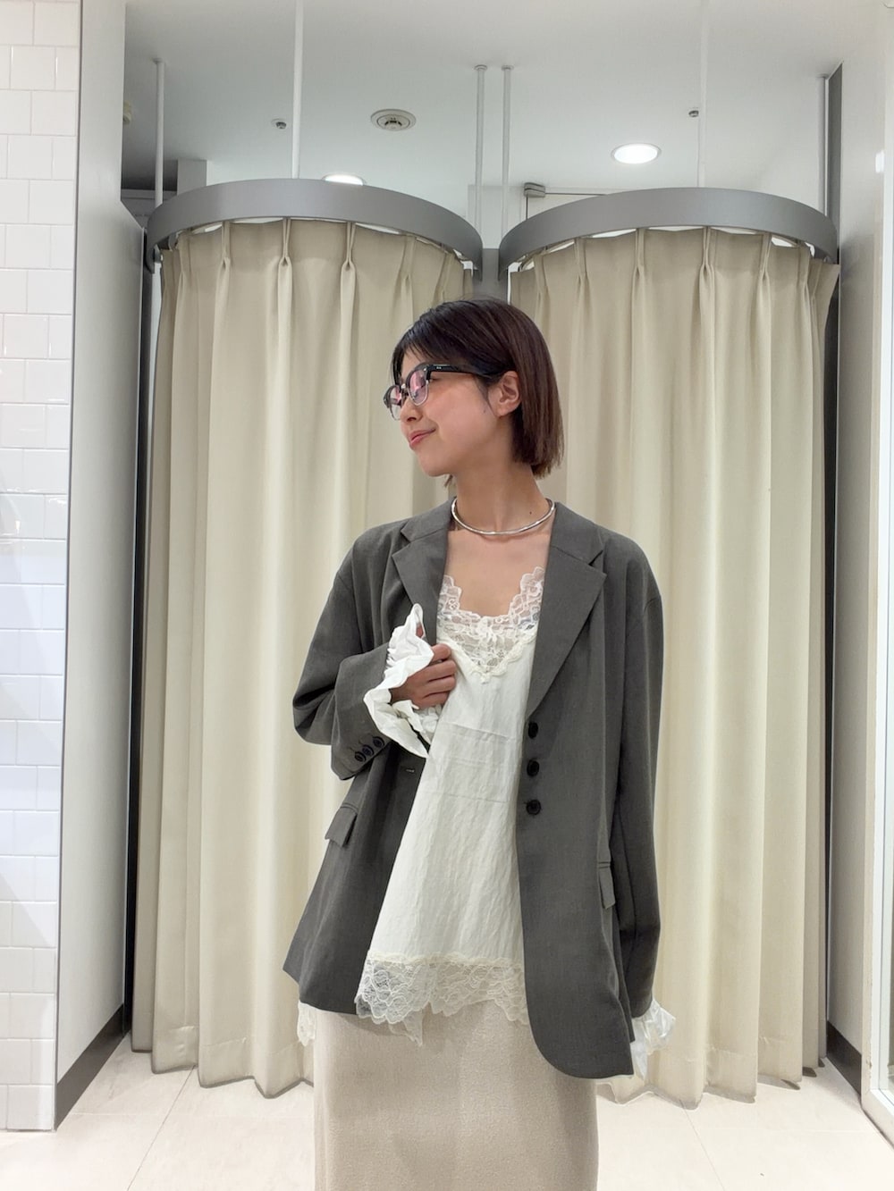 グレー系のその他アウター、ホワイト系のスカート、ホワイト系のシャツ/ブラウスを着用したレディースの春コーディネートの2枚目の写真