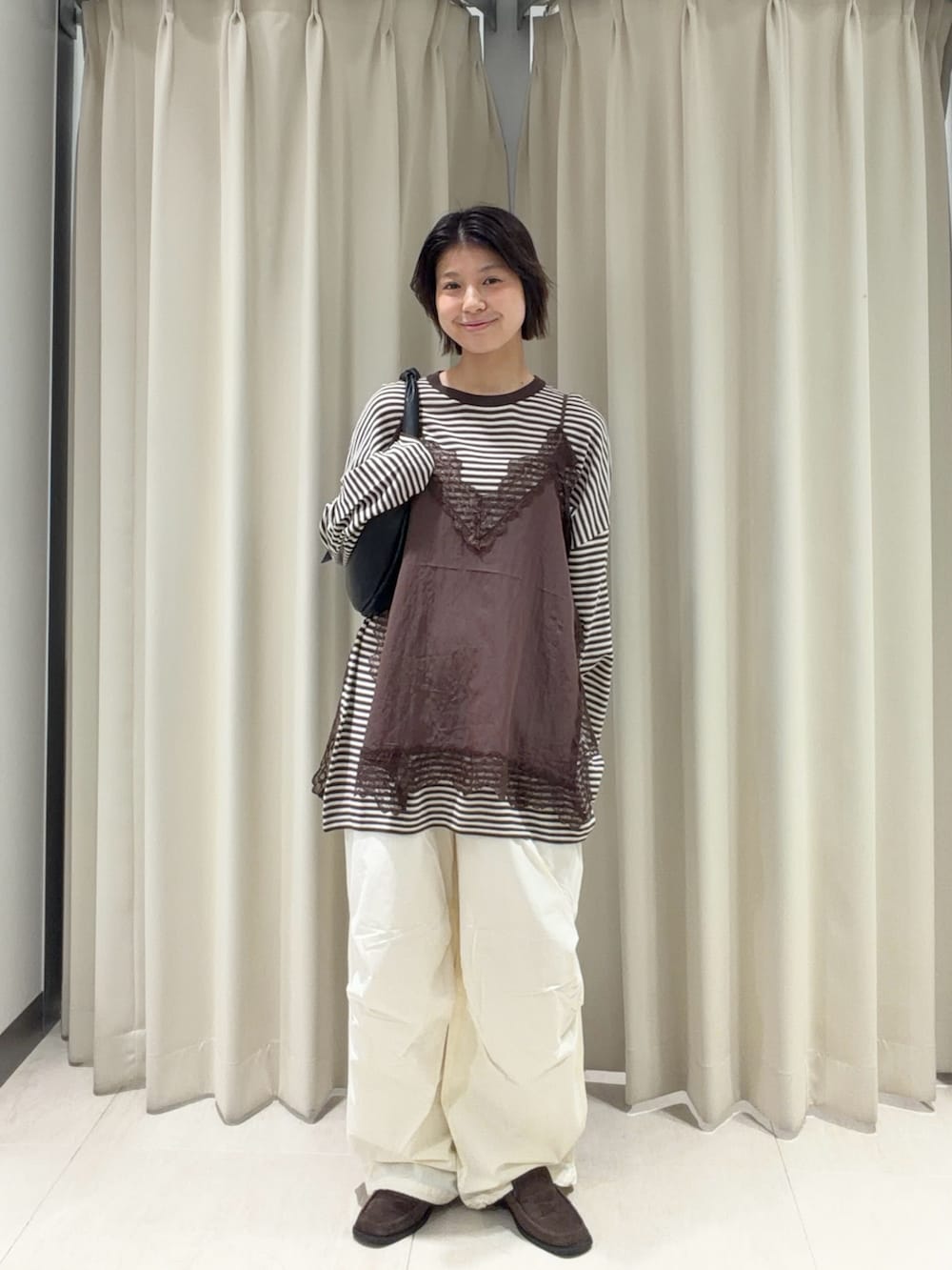 ブラウン系のキャミソール、ブラウン系のニット/セーター、ホワイト系のその他パンツを着用したレディースの春コーディネートの2枚目の写真