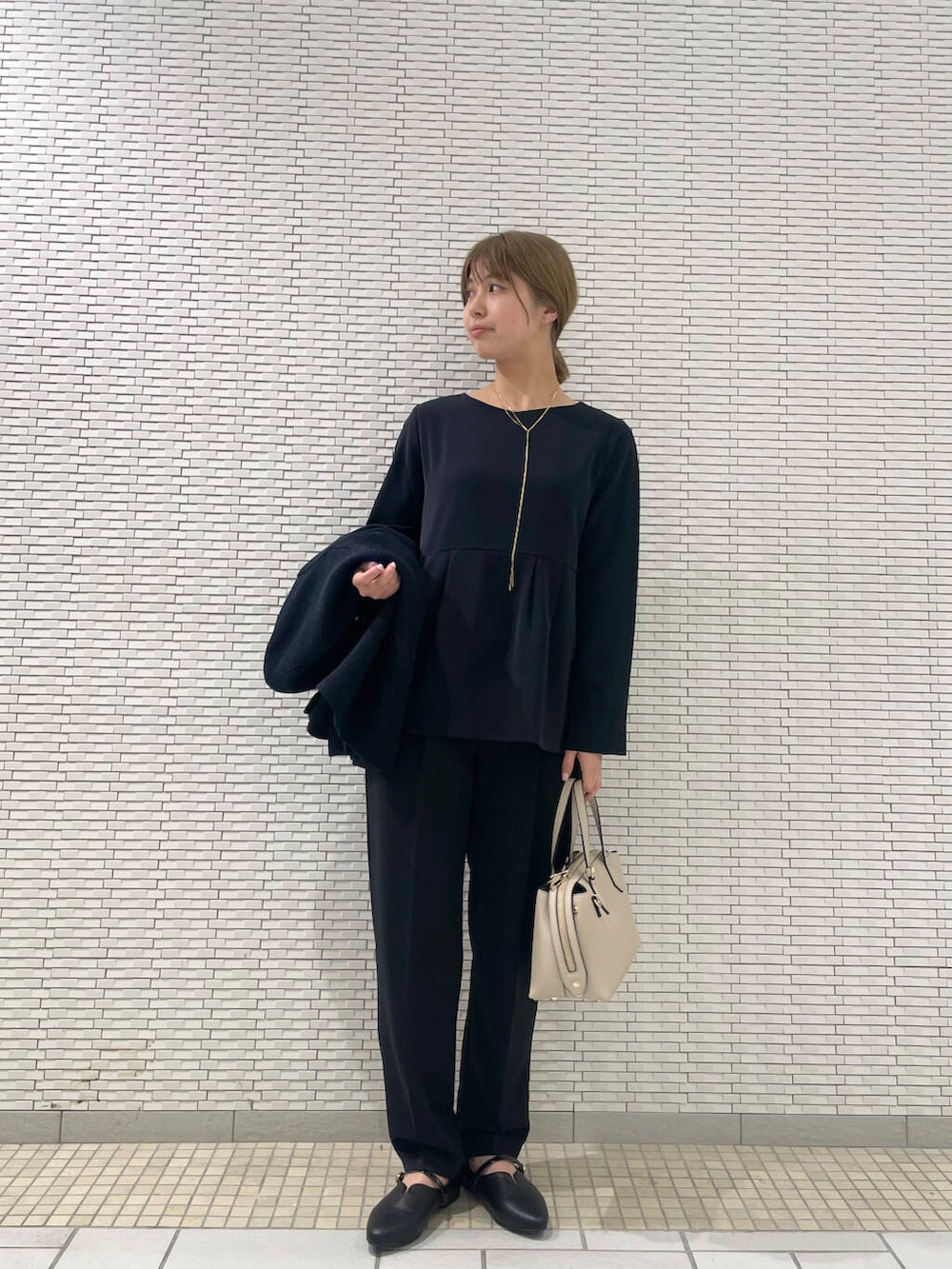 ブルー系のセットアップ、ブルー系のスーツジャケット、ブラック系のパンプスを着用したレディースの冬コーディネートの2枚目の写真