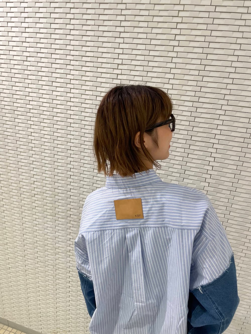 ブルー系のデニムパンツ、ブルー系のシャツ/ブラウス、ブラウン系のメガネを着用したレディースの夏コーディネートの5枚目の写真