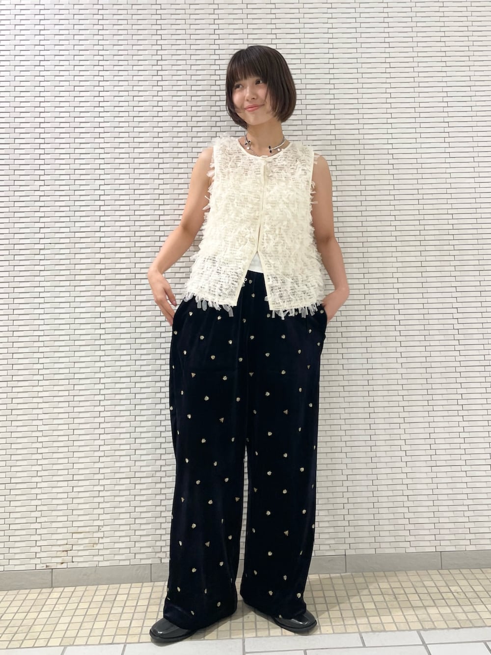 ブルー系のその他パンツ、ホワイト系のベスト、ブラック系のその他シューズを着用したレディースの秋コーディネートの3枚目の写真