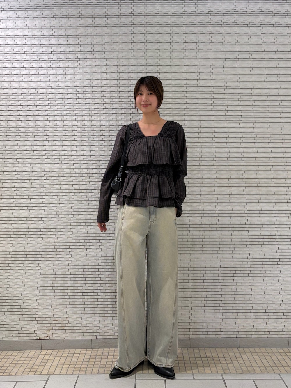 ブラウン系のシャツ/ブラウス、ブルー系のデニムパンツ、ブラック系のショルダーバッグを着用したレディースの秋コーディネートの3枚目の写真