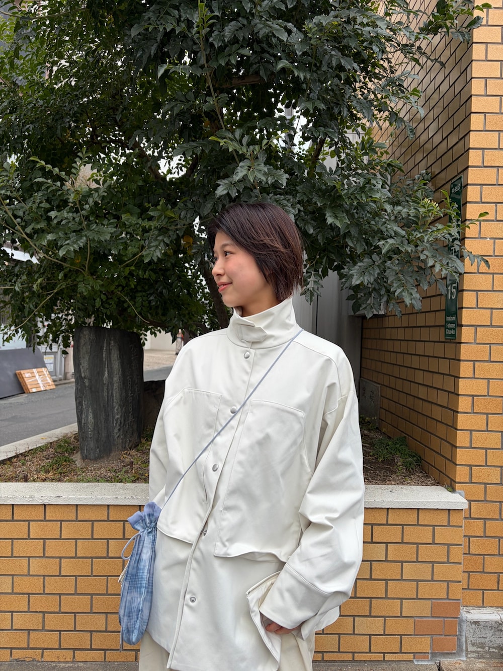 ホワイト系のその他アウター、ブラウン系のローファーを着用したレディースの春コーディネートの4枚目の写真