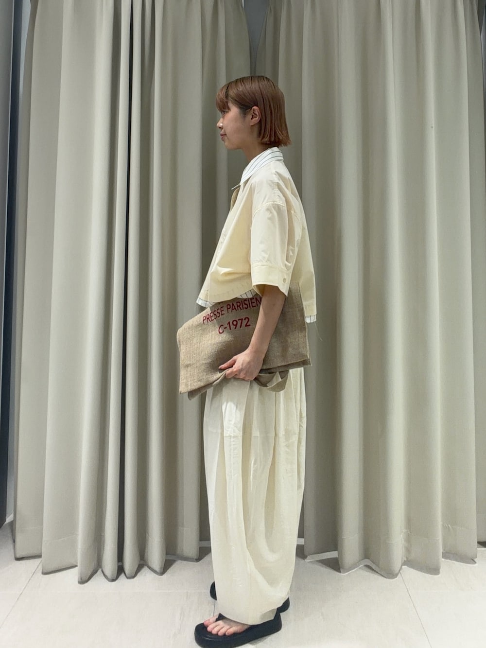 イエロー系のシャツ/ブラウス、ホワイト系のその他パンツ、ブラック系のサンダルを着用したレディースの夏コーディネートの2枚目の写真
