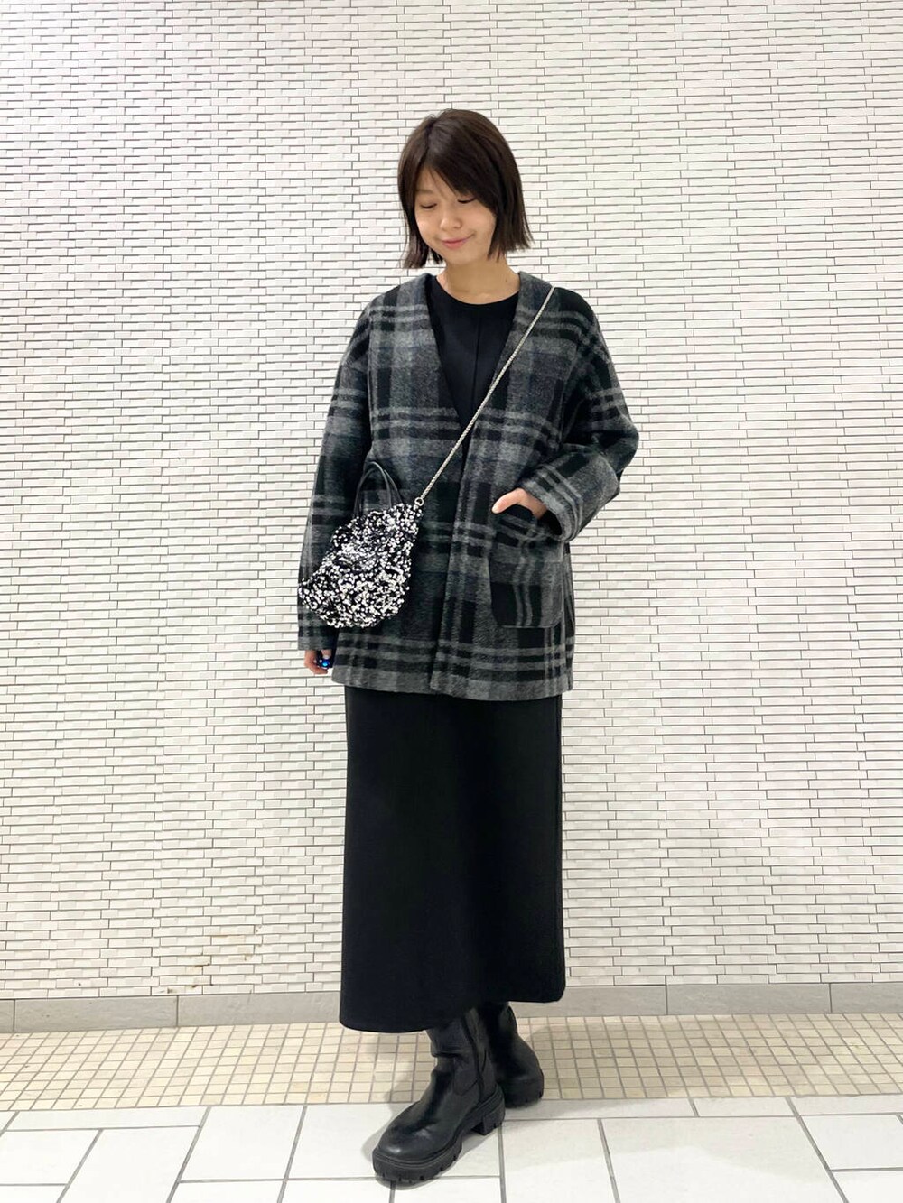 シルバー系のショルダーバッグ、ブラック系のブーツ、グレー系のその他アウターを着用したレディースの秋コーディネートの4枚目の写真
