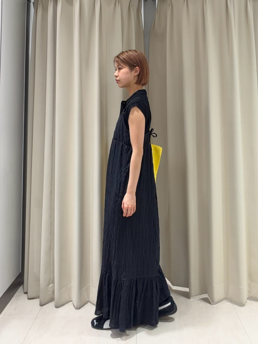 ブラック系のワンピース、ブラック系のニット/セーター、ブラック系のスニーカーを着用したレディースの春コーディネートの2枚目の写真