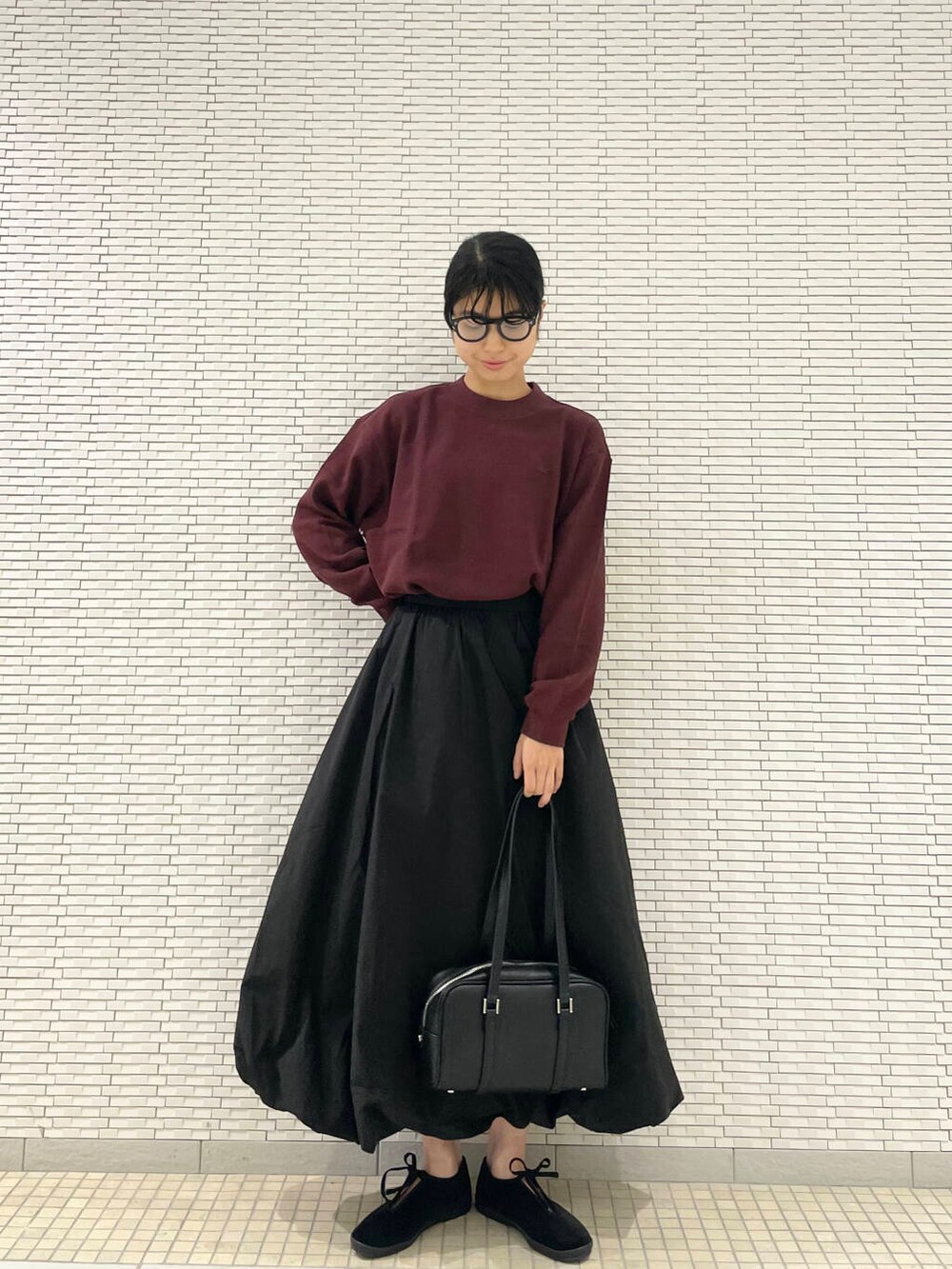 ブラック系のその他シューズ、ブラック系のスカート、レッド系のTシャツ/カットソーを着用したレディースの秋コーディネートの2枚目の写真