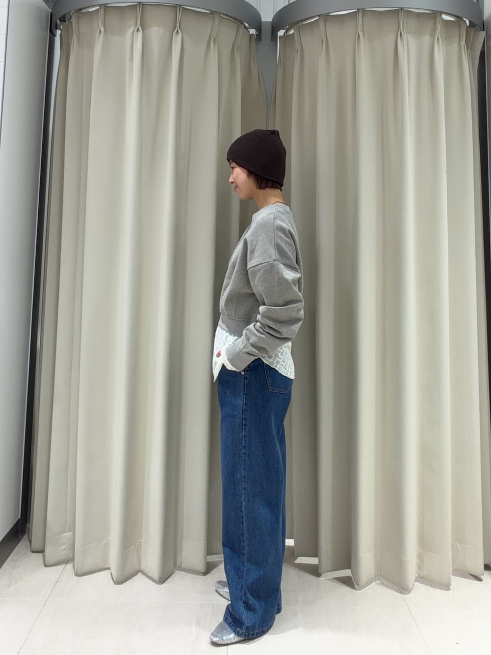 ベージュ系のスウェット、ブルー系のデニムパンツ、ホワイト系のTシャツ/カットソーを着用したレディースの春コーディネートの2枚目の写真