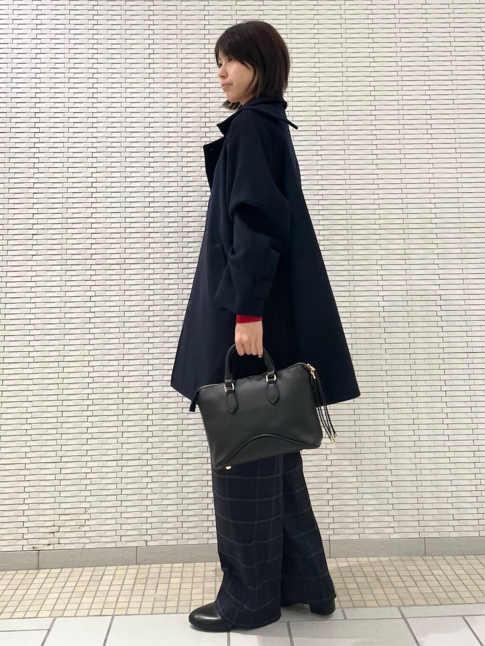 レッド系のニット/セーター、ブラック系のローファー、ブルー系のピーコートを着用したレディースの冬コーディネートの3枚目の写真