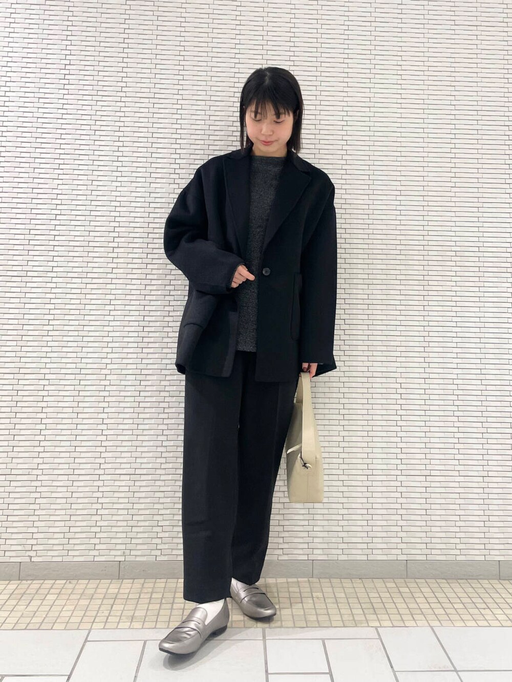 ブラック系のその他アウター、シルバー系のローファー、ブラック系のその他パンツを着用したレディースの冬コーディネートの2枚目の写真