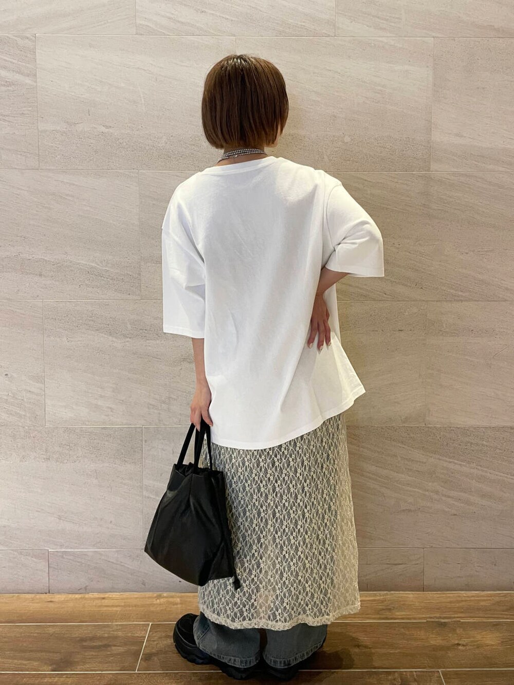 ブルー系のデニムパンツ、ホワイト系のTシャツ/カットソー、ブラック系のスニーカーを着用したレディースの夏コーディネートの4枚目の写真