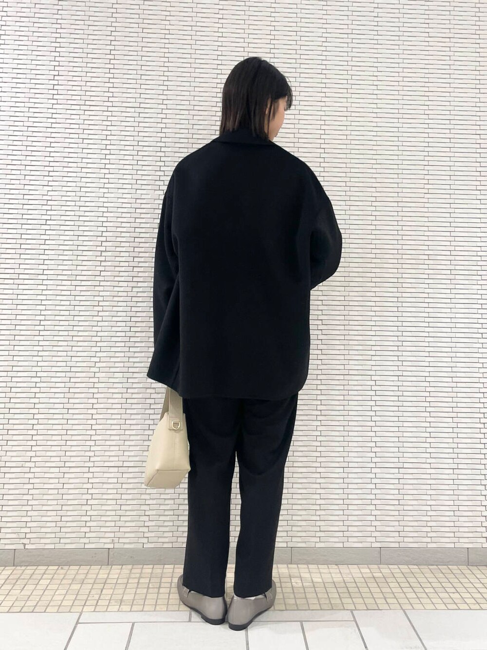 ブラック系のその他アウター、シルバー系のローファー、ブラック系のその他パンツを着用したレディースの冬コーディネートの4枚目の写真
