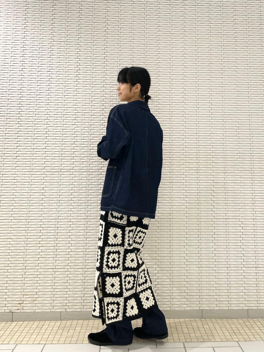 ブラック系のその他シューズ、ブルー系のデニムパンツ、ホワイト系のワンピースを着用したレディースの秋コーディネートの5枚目の写真