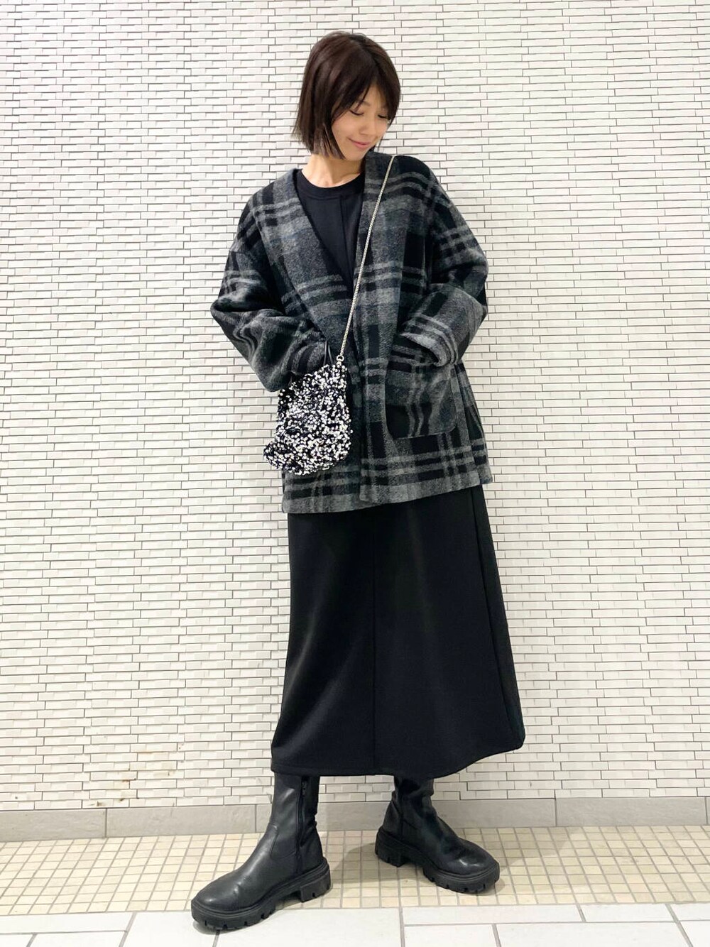 シルバー系のショルダーバッグ、ブラック系のブーツ、グレー系のその他アウターを着用したレディースの秋コーディネートの5枚目の写真
