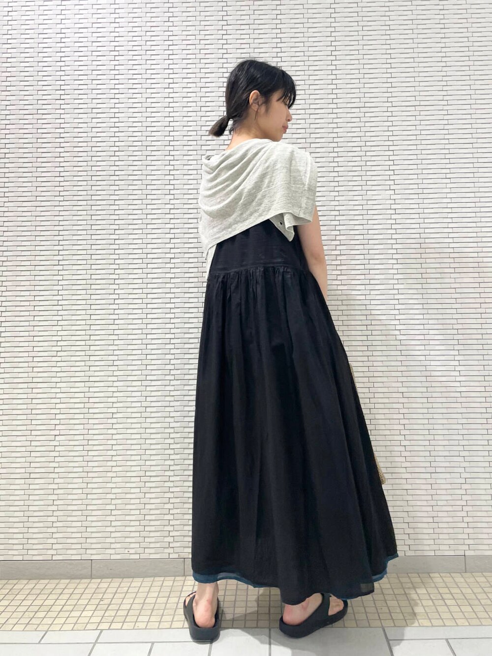 グレー系のカーディガン/ボレロ、ブラック系のワンピース、グレー系のトートバッグを着用したレディースの夏コーディネートの3枚目の写真