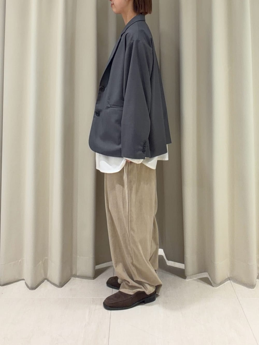 ベージュ系のその他パンツ、グレー系のその他アウター、ブラウン系のローファーを着用したレディースの春コーディネートの2枚目の写真