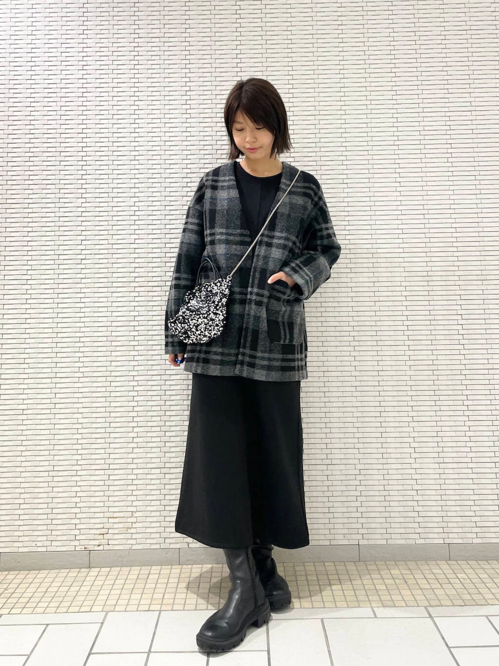 シルバー系のショルダーバッグ、ブラック系のブーツ、グレー系のその他アウターを着用したレディースの秋コーディネートの2枚目の写真