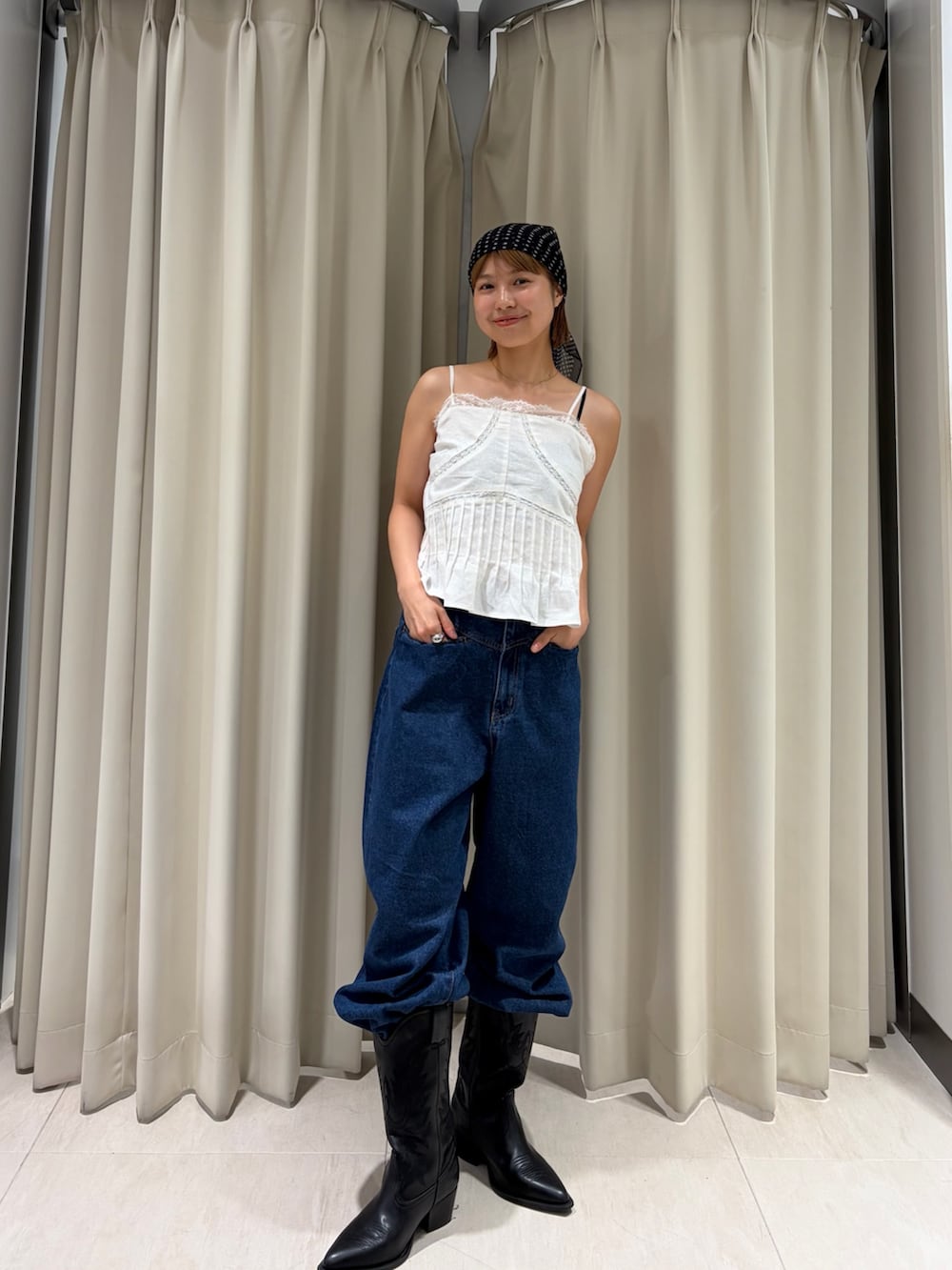 ブルー系のデニムパンツ、ホワイト系のキャミソールを着用したレディースの夏コーディネートの2枚目の写真