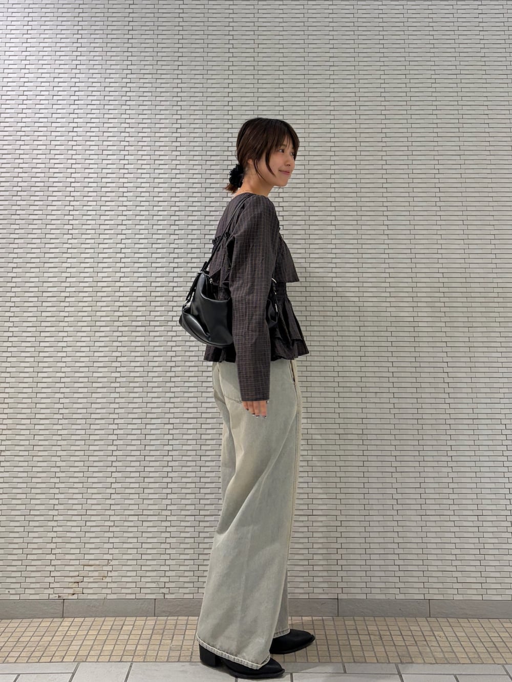 ブラウン系のシャツ/ブラウス、ブルー系のデニムパンツ、ブラック系のショルダーバッグを着用したレディースの秋コーディネートの2枚目の写真