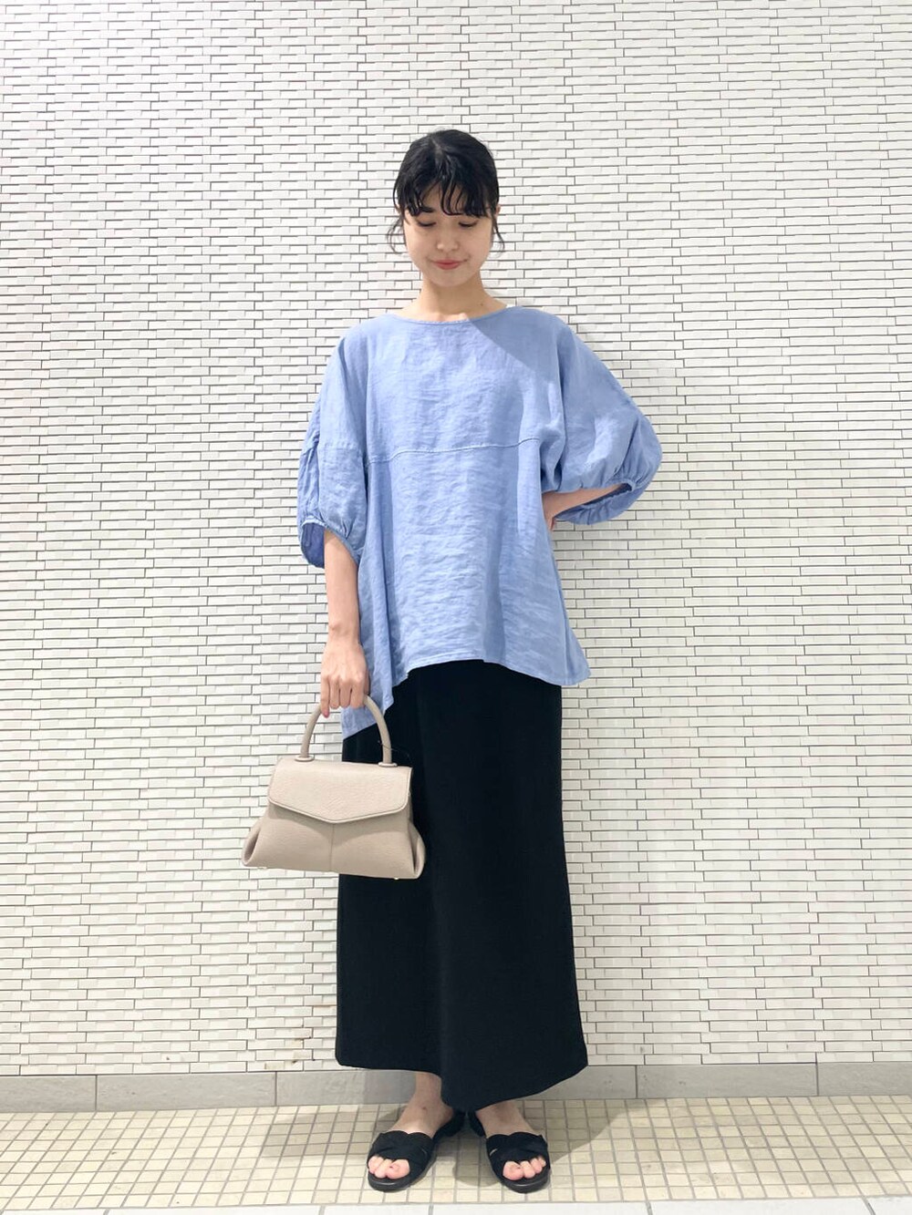 ブルー系のシャツ/ブラウス、ブラック系のサンダル、ブラック系のスカートを着用したレディースの夏コーディネートの3枚目の写真