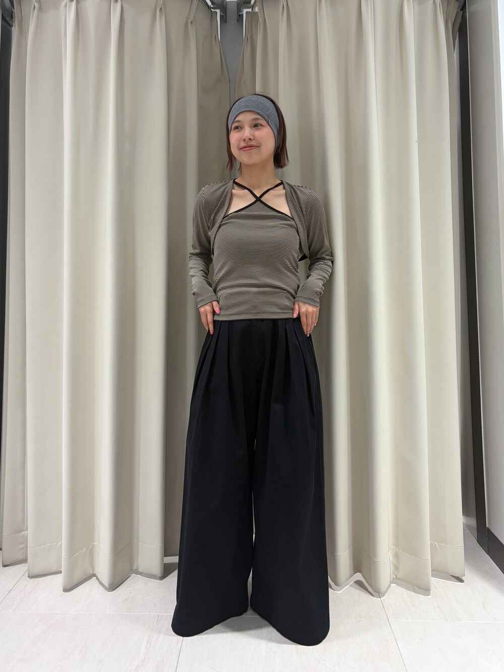 ベージュ系のキャミソール、ブラック系のその他パンツ、グレー系のヘアバンドを着用したレディースの春コーディネートの3枚目の写真