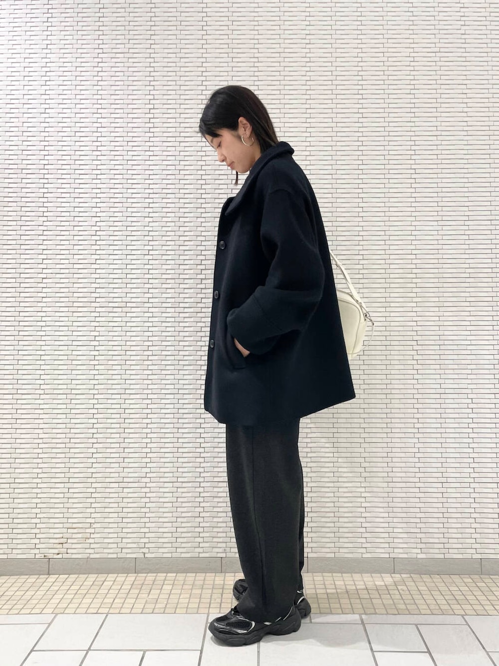 グレー系のニット/セーター、ブラック系のその他アウター、グレー系のその他パンツを着用したレディースの冬コーディネートの2枚目の写真